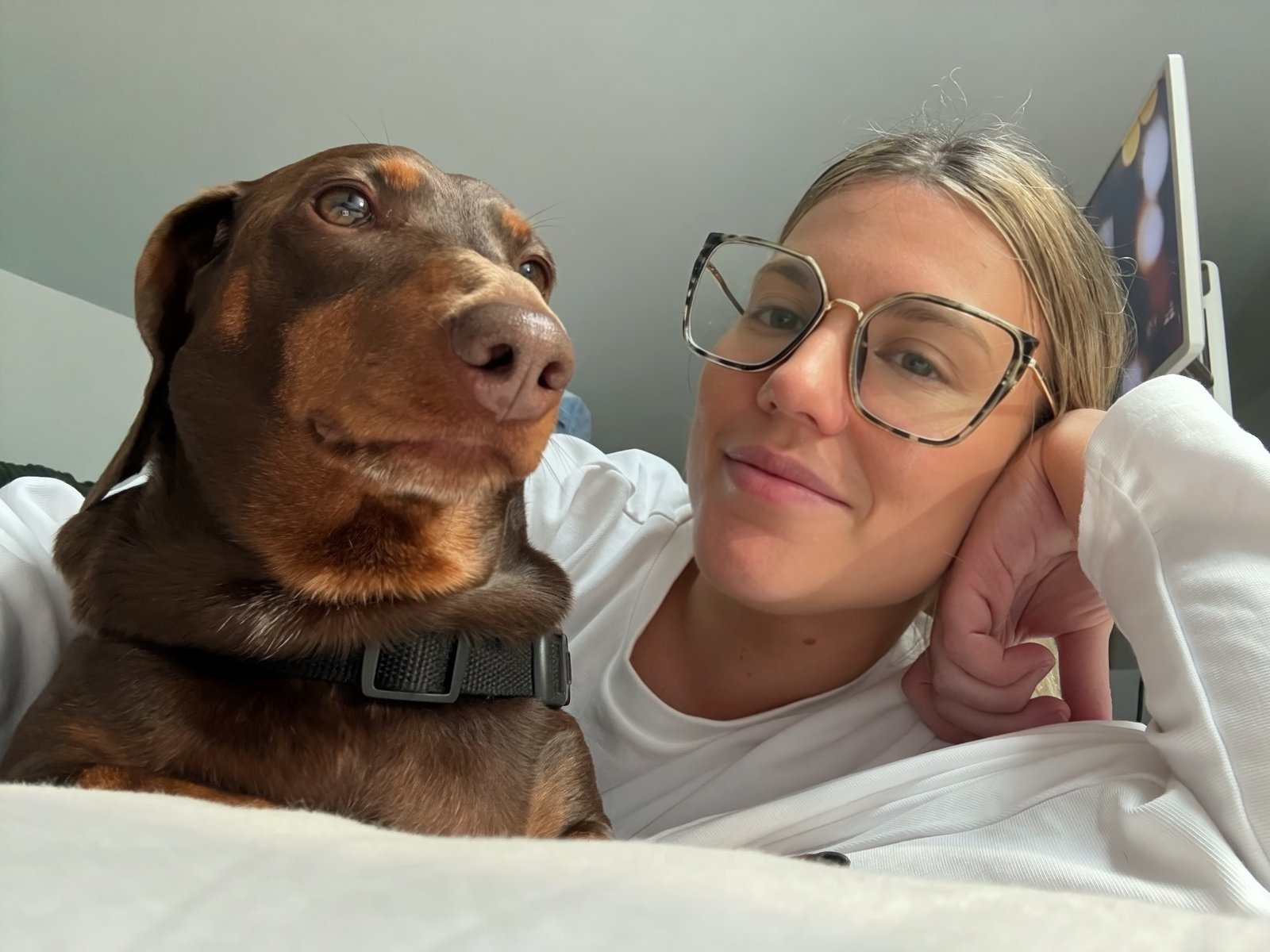 Ash posing with a dachshund wearing novelty glasses